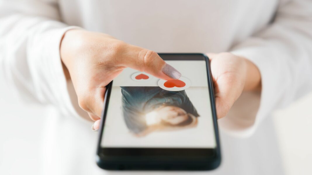 woman finger touching heart icon on screen in smartphone application