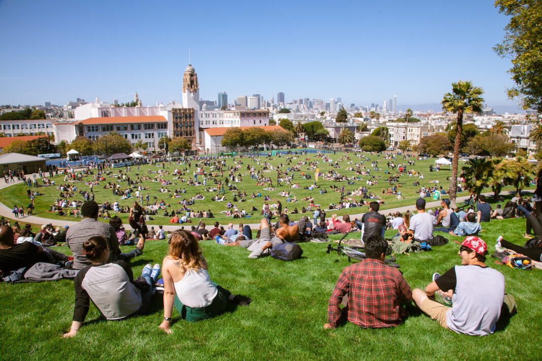 people sitting on grass at dolores park sf