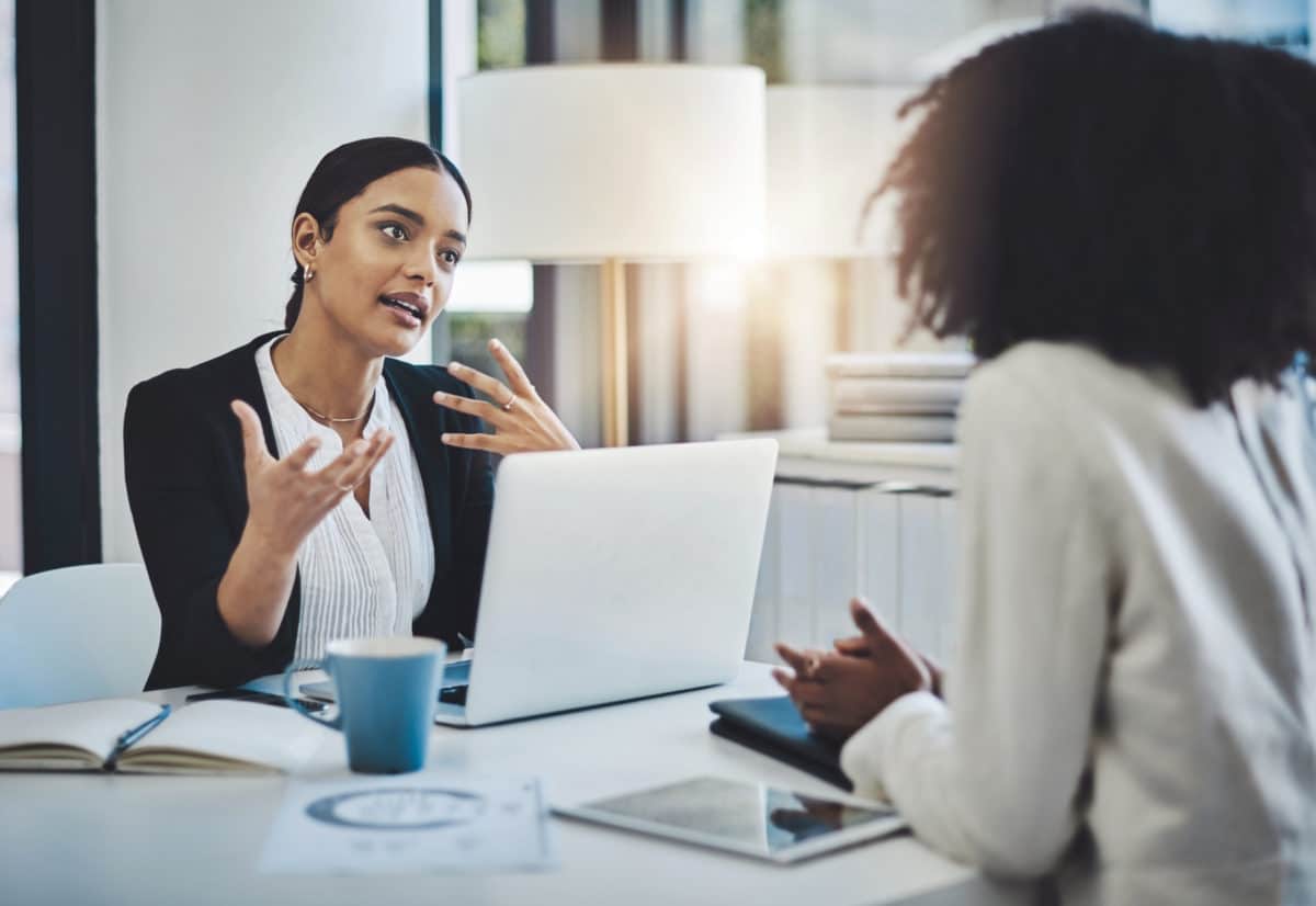 two women talking and negotiating broker fees