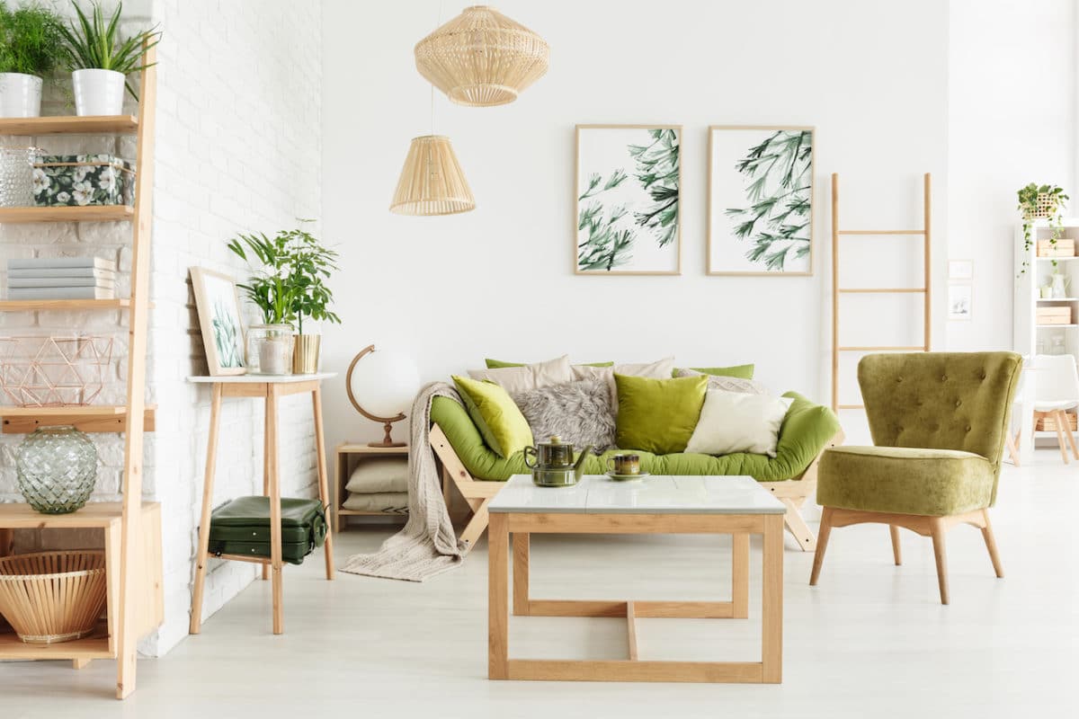 living room with green accents, table, couch, and plant