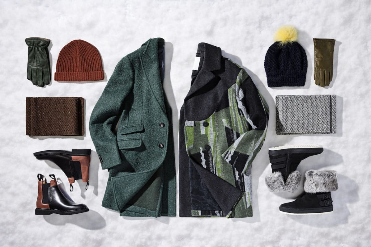 winter hats, coats, and gloves on snowy background