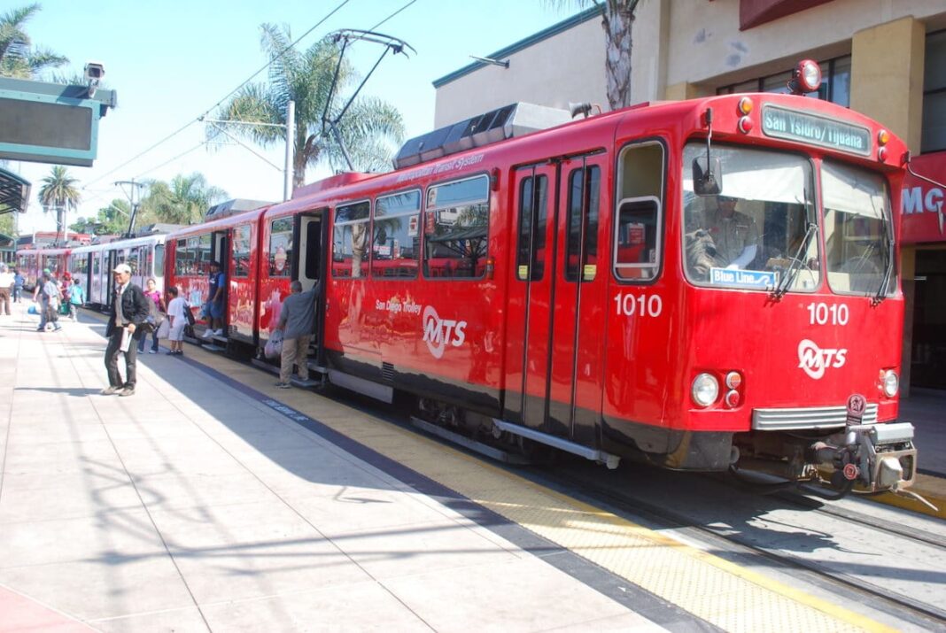 Red San diego Trolley with people getting on and off the train during the day