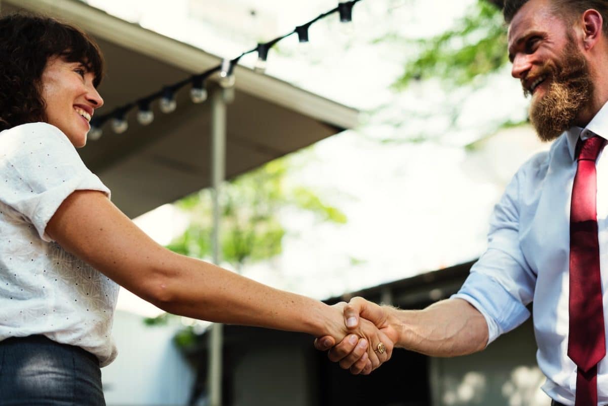 man and woman shaking hands and smiling