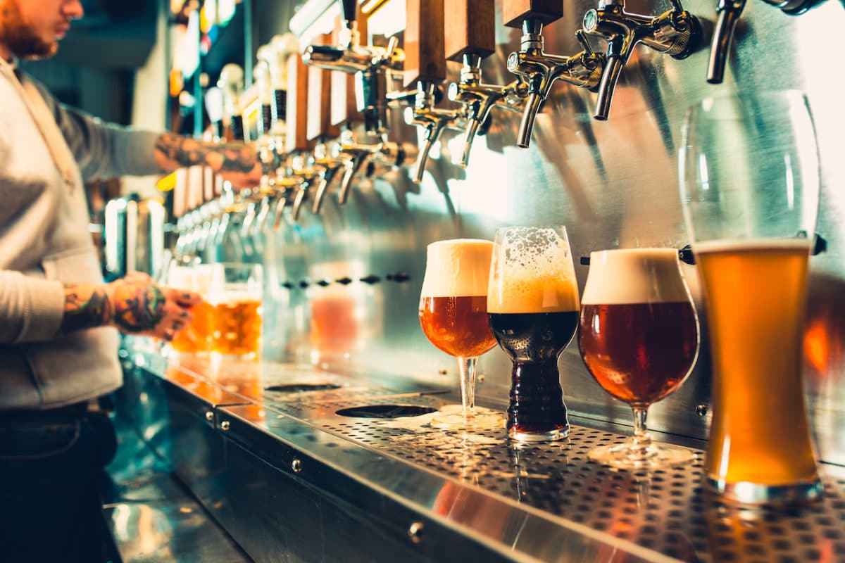 Beers being poured from the tap by bartender 