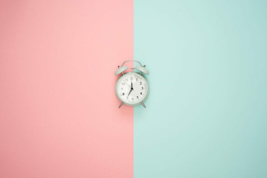 alarm clock on half blue half pink bakcground