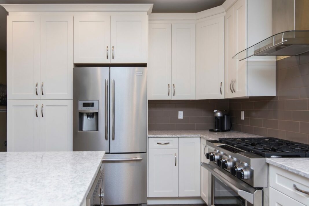 clean kitchen with white cabinets and a silver refrigerator