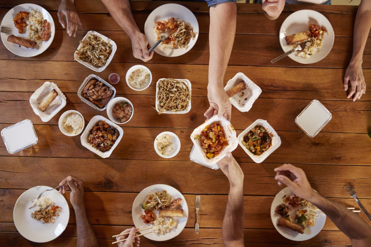Friends at a table sharing Chinese take-away, overhead view