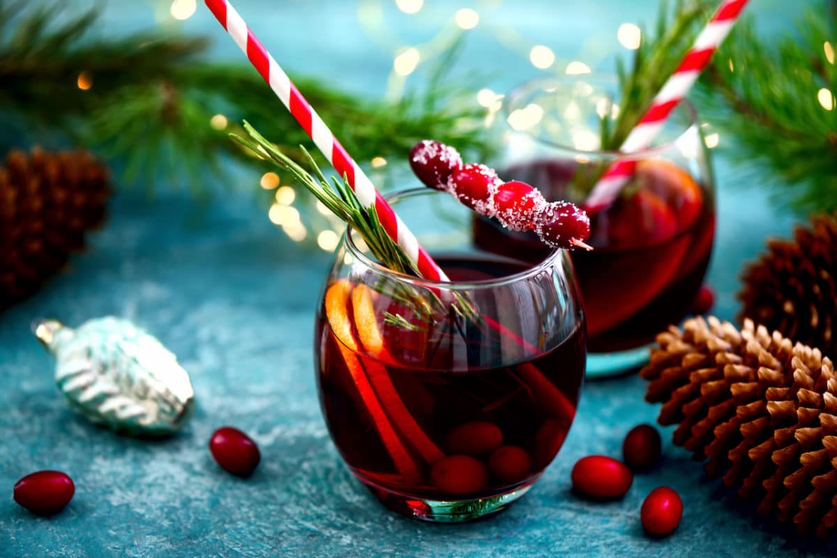 Holiday punch with red and white straws on a blue table top