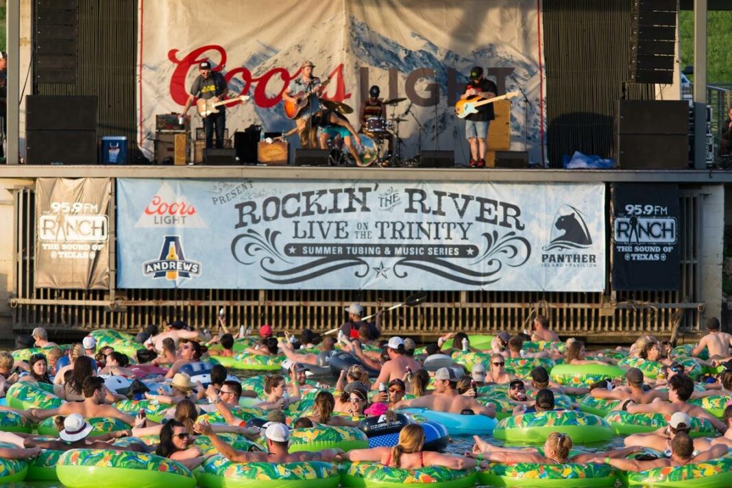 people floating in green inner-tubes and a band playing on stage above them