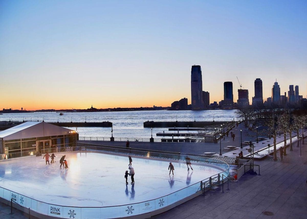 sun setting over the brookfield ice rink with city buildings in the backdrop