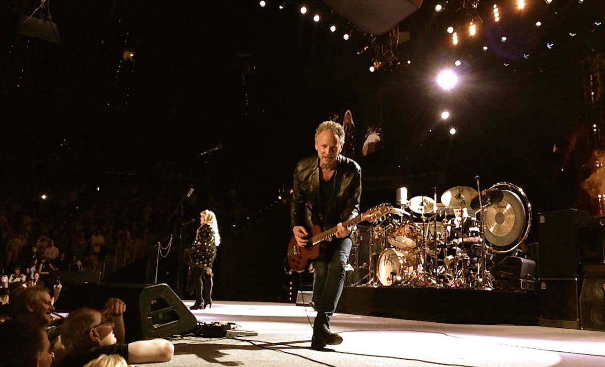 man playing guitar and performing on stage