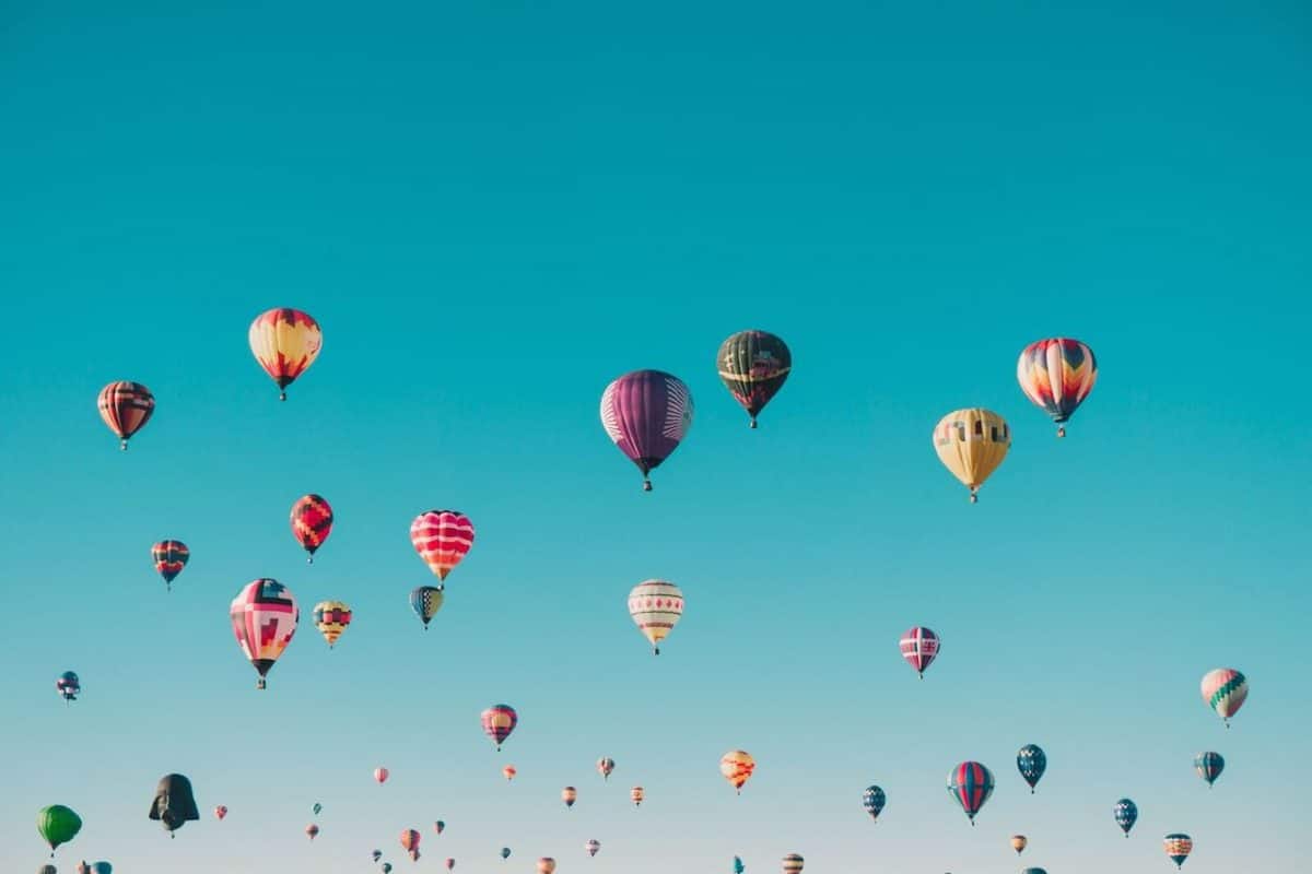 Multi-colored hot air balloons in blue sky