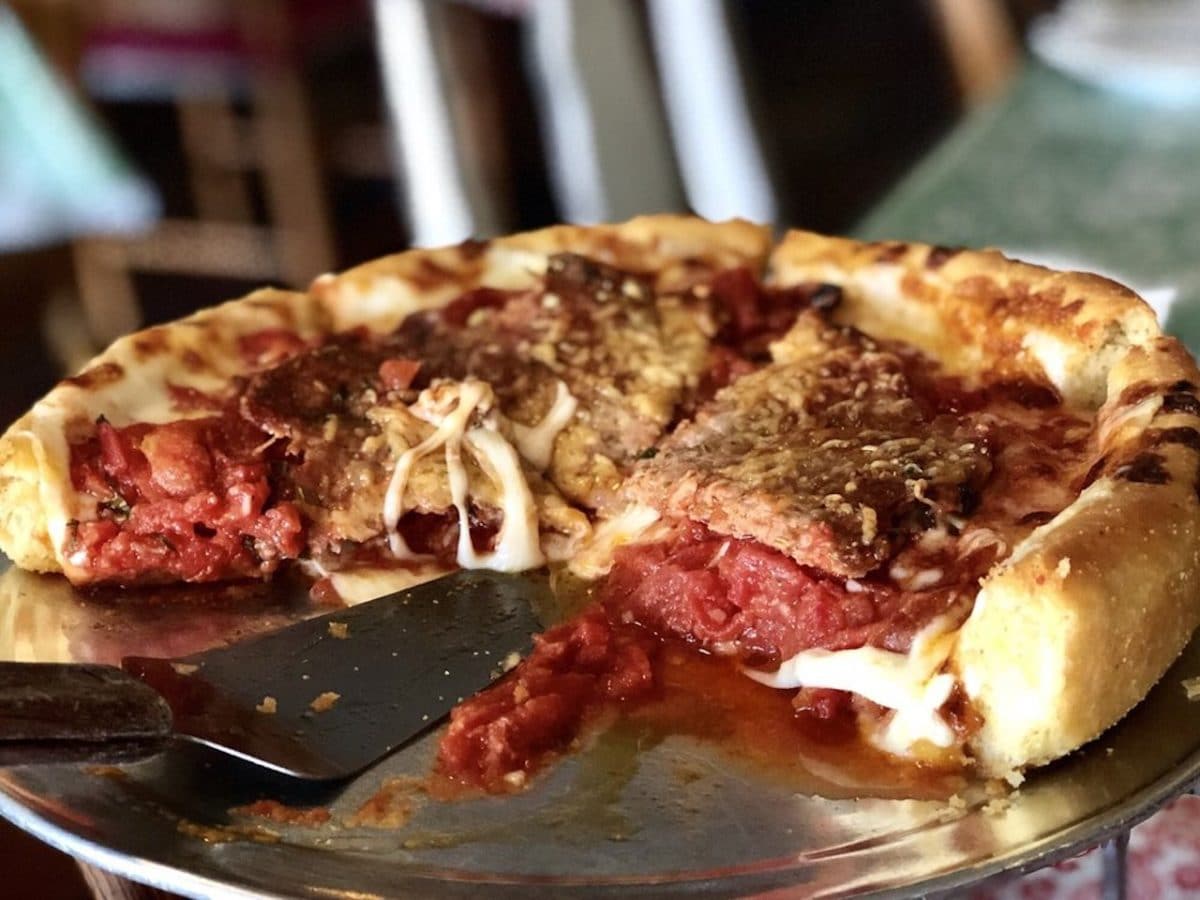 Close up shot of deep dish meat pizza on silver tray