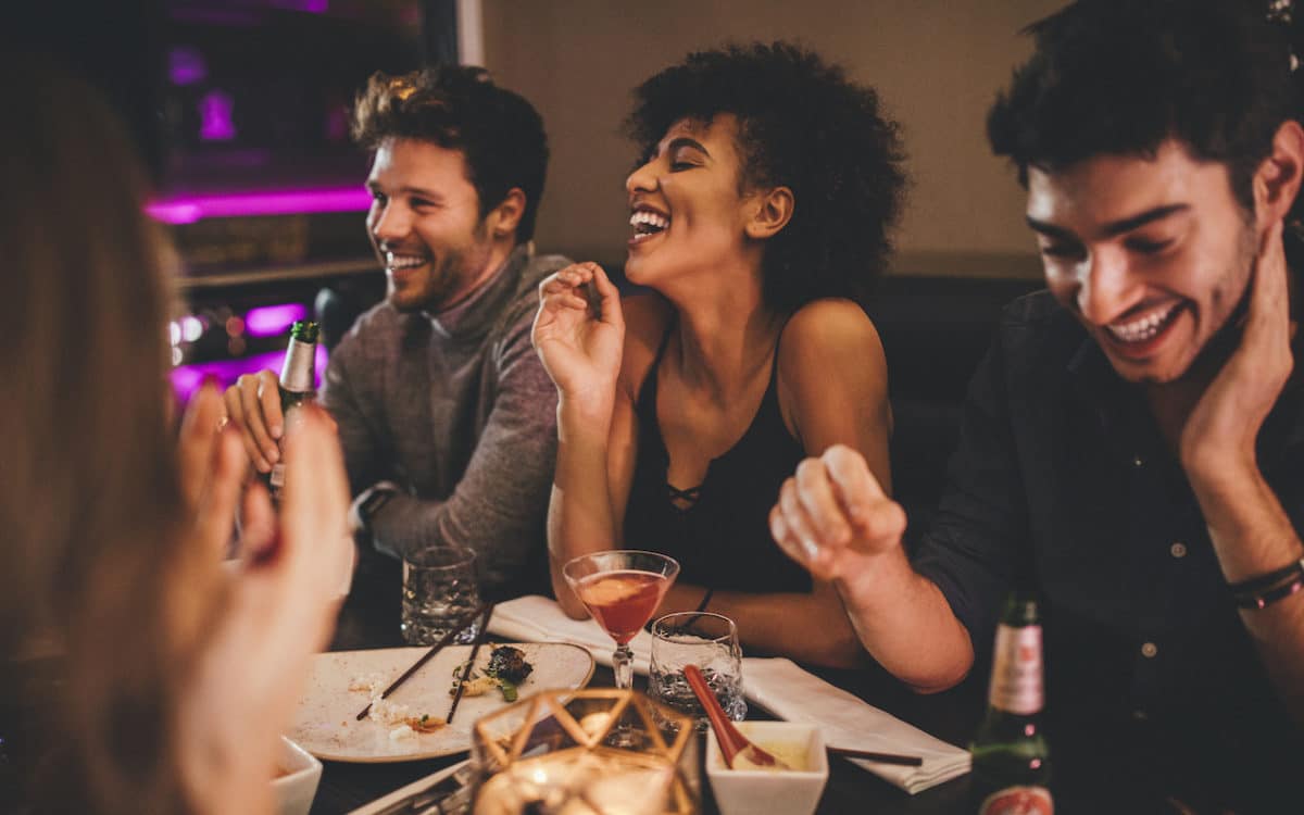 Friends sitting at restaurant table laughing