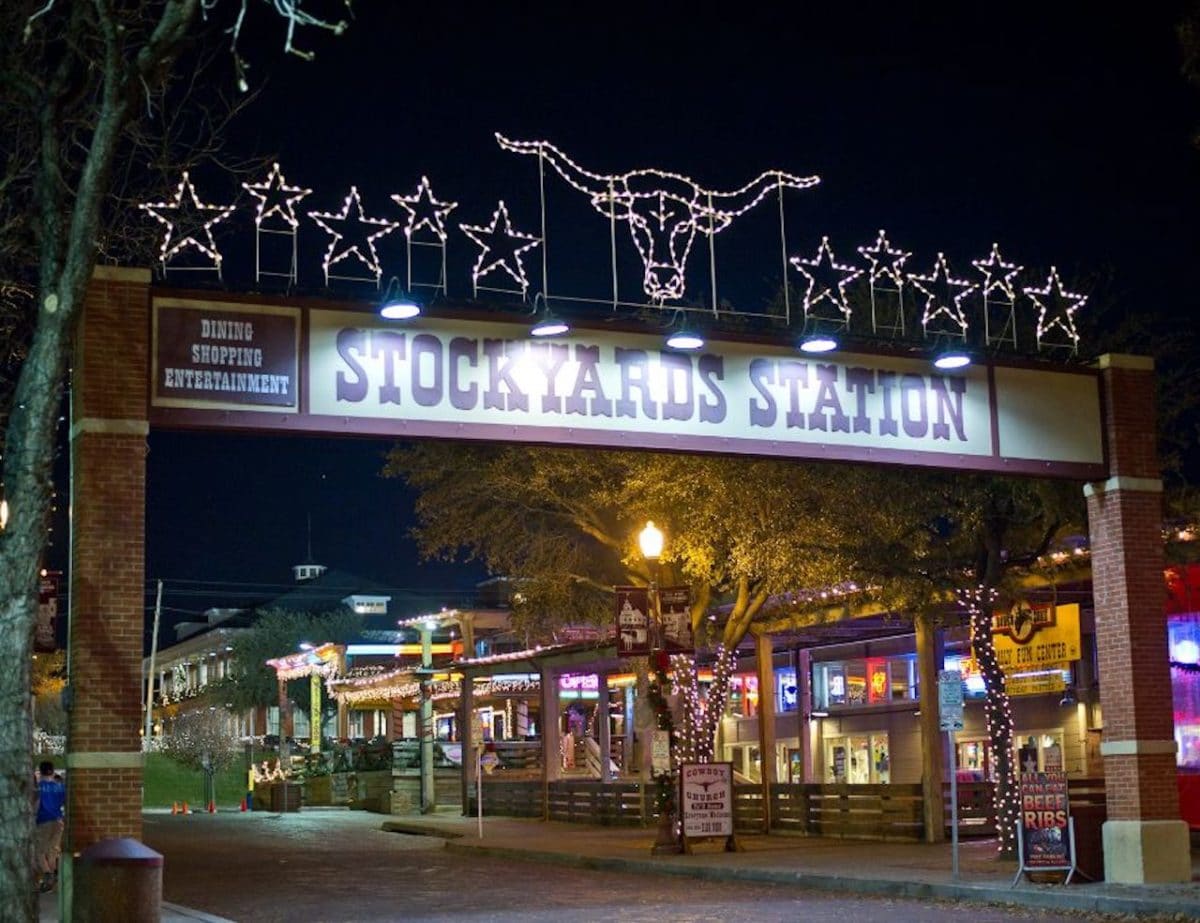 Stockyard Station sign with shops and main road in view