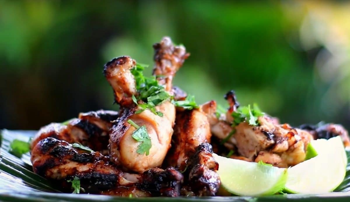 bbq wings on a plate with lime wedges