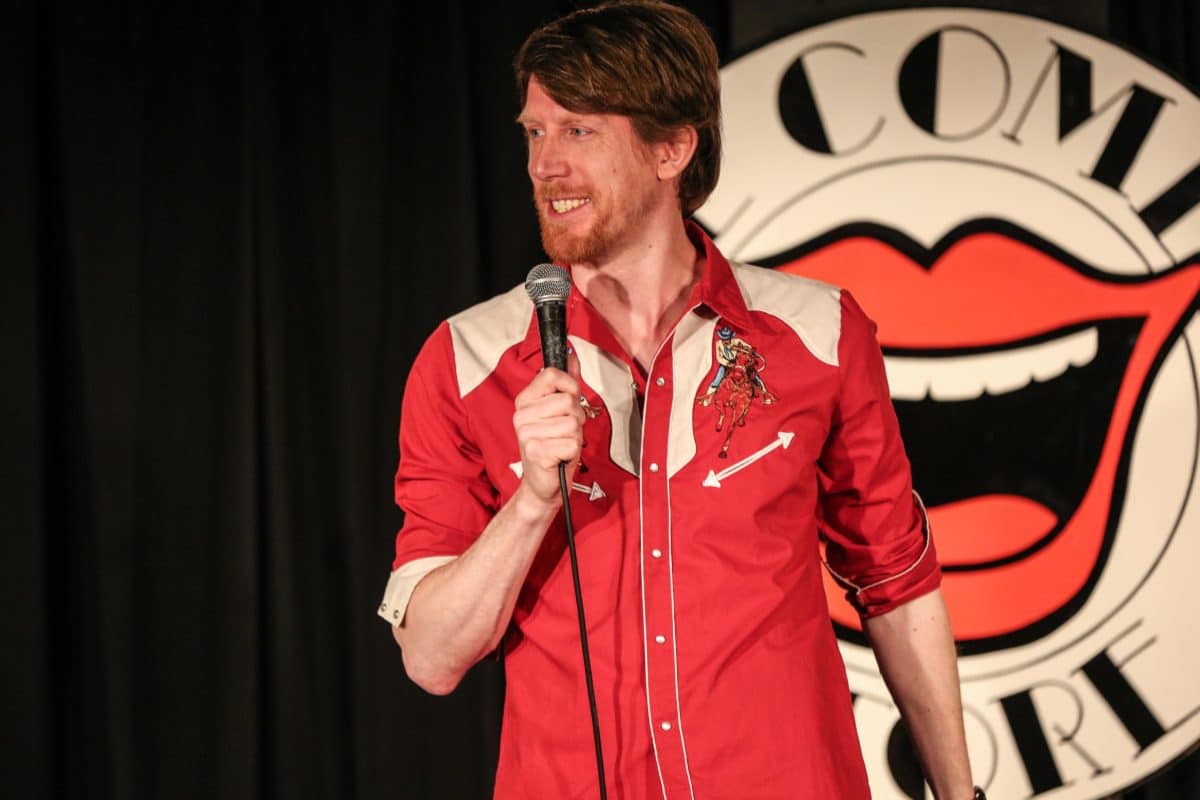 close up of man on stage doing stand up comedy
