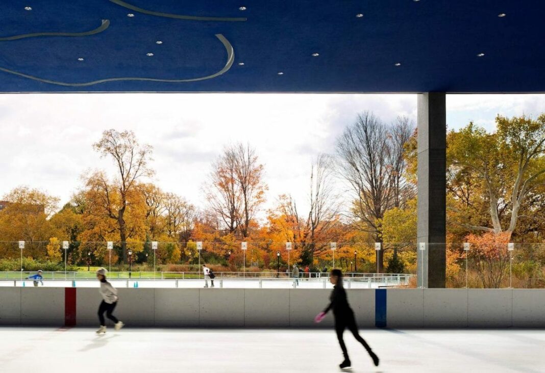 female skating on the ice rink with fall trees in the background