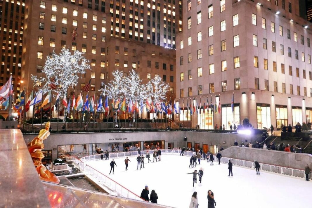 ice skating rink in between buildings with a few people on it