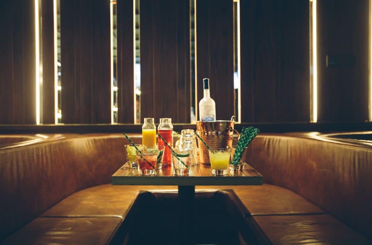 dark room with table filled with cocktails and booth