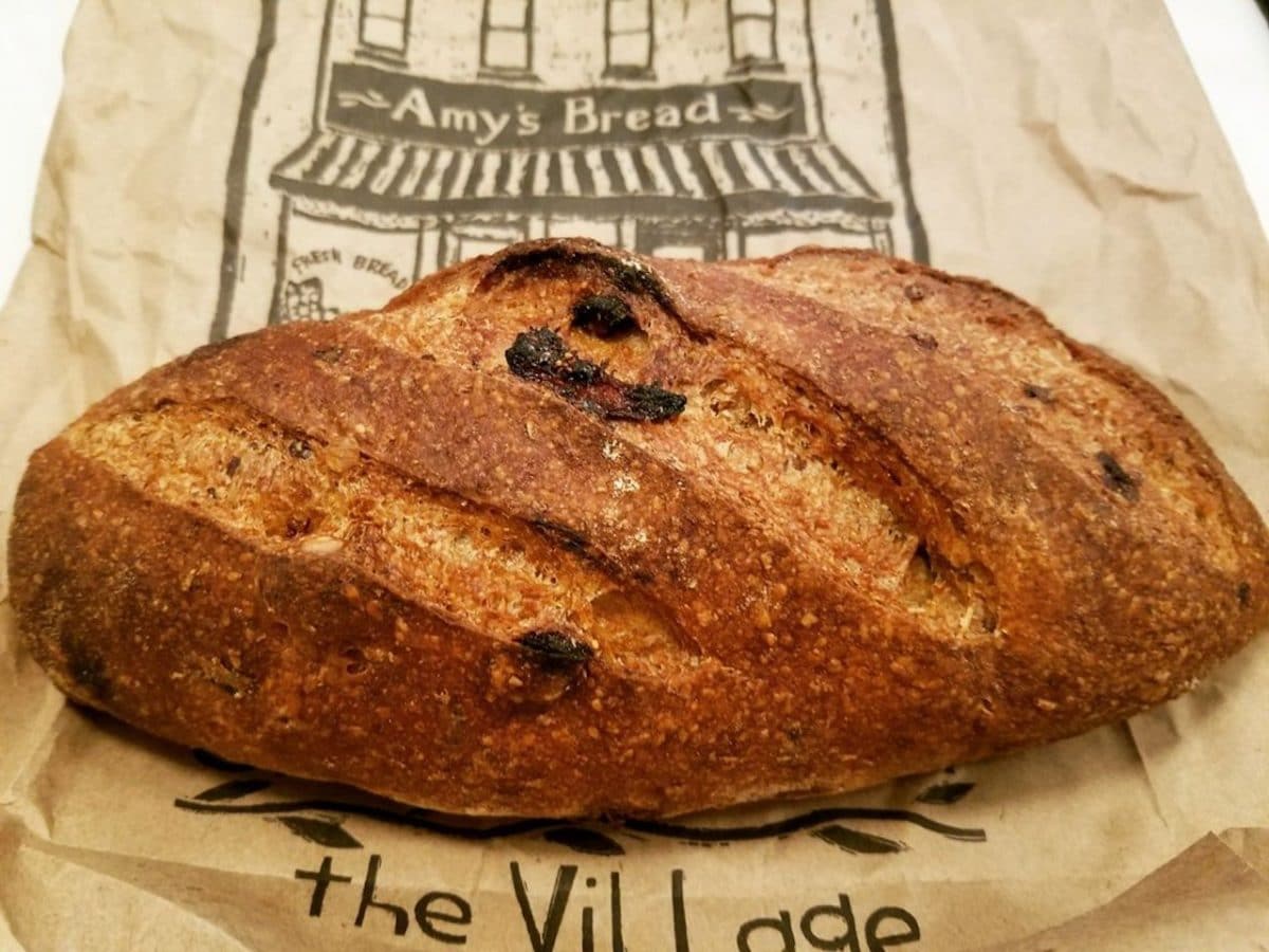 bag reading amy's bread with a loaf of brown bread on top of it