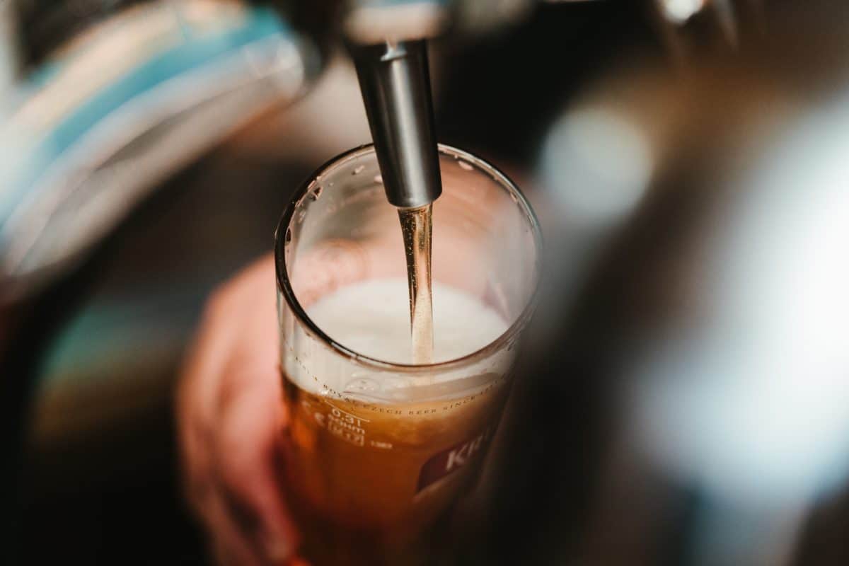 close up of beer being poured from a tap
