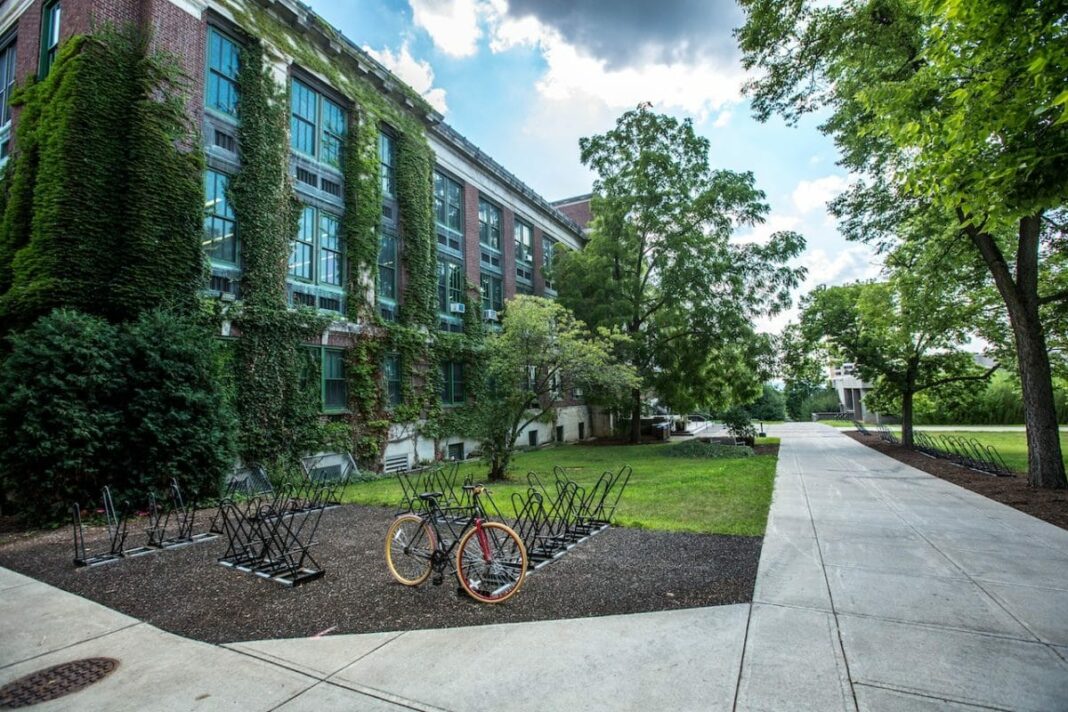 college campus buildings with single bike locked at bike rack 