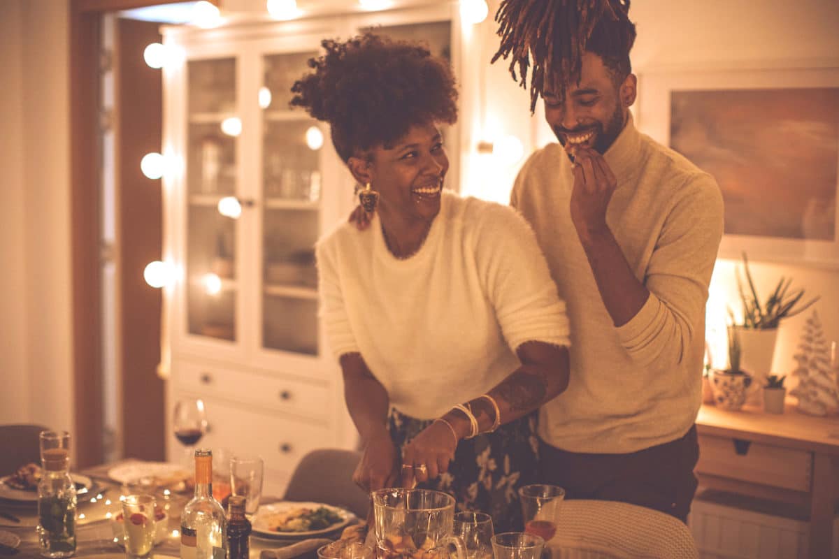 two people cooking in their kitchen with lights down low