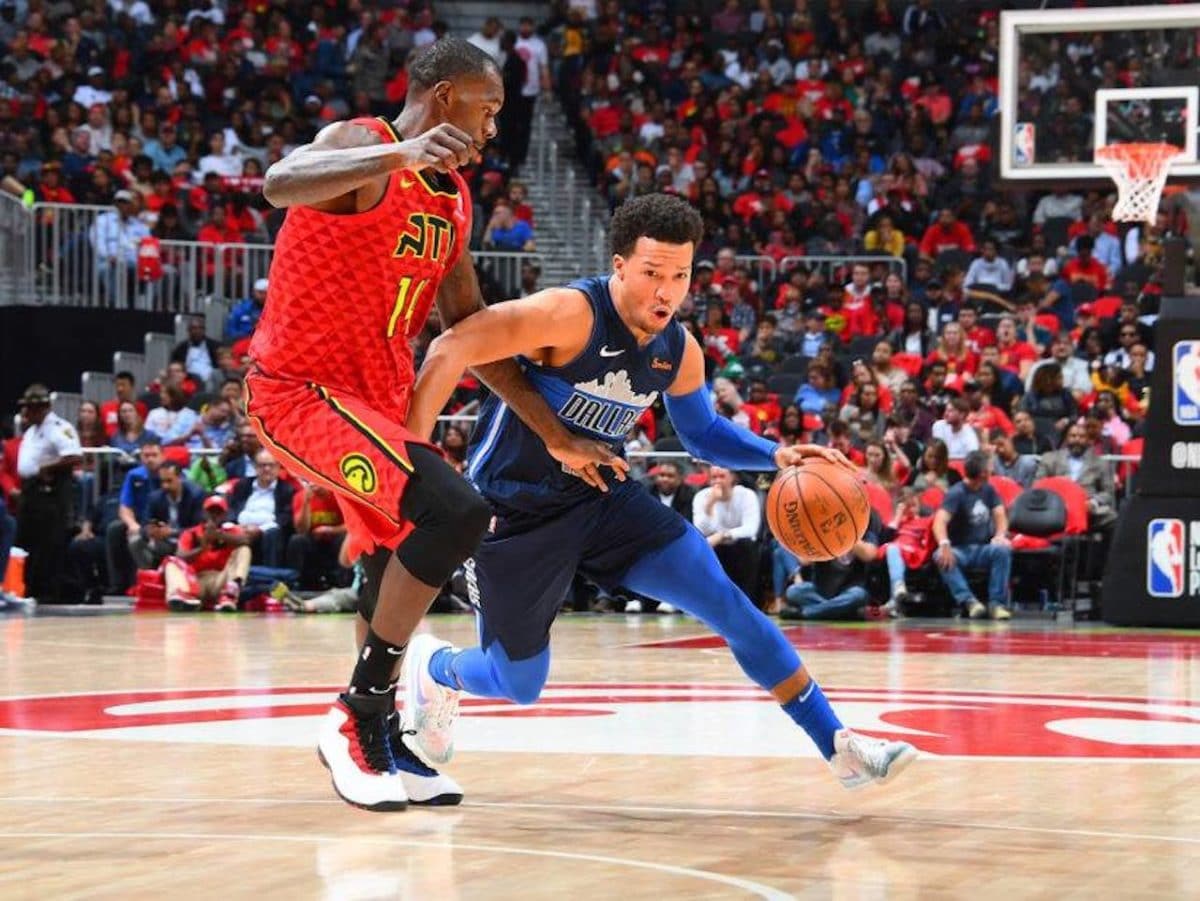 basketball player driving past defender to the rim