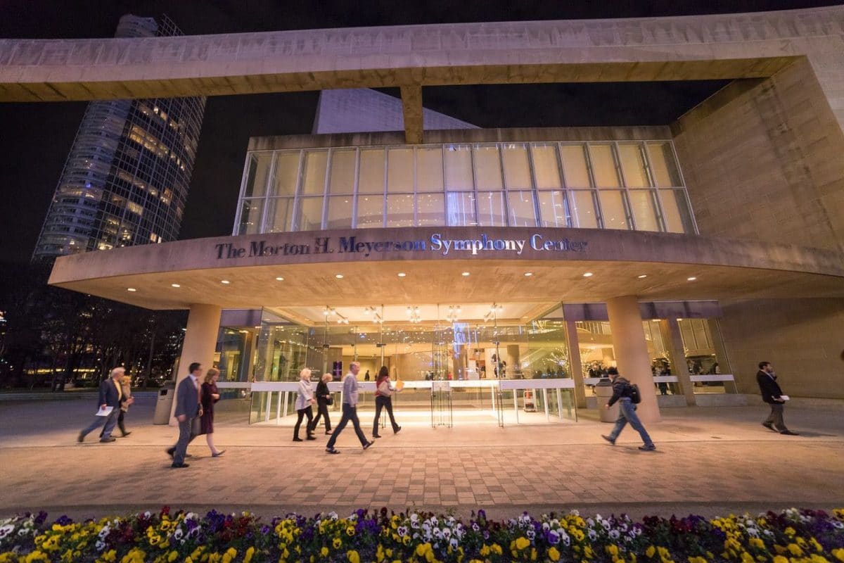 exterior of the dallas symphony orchestra with people walking into and out of the doors