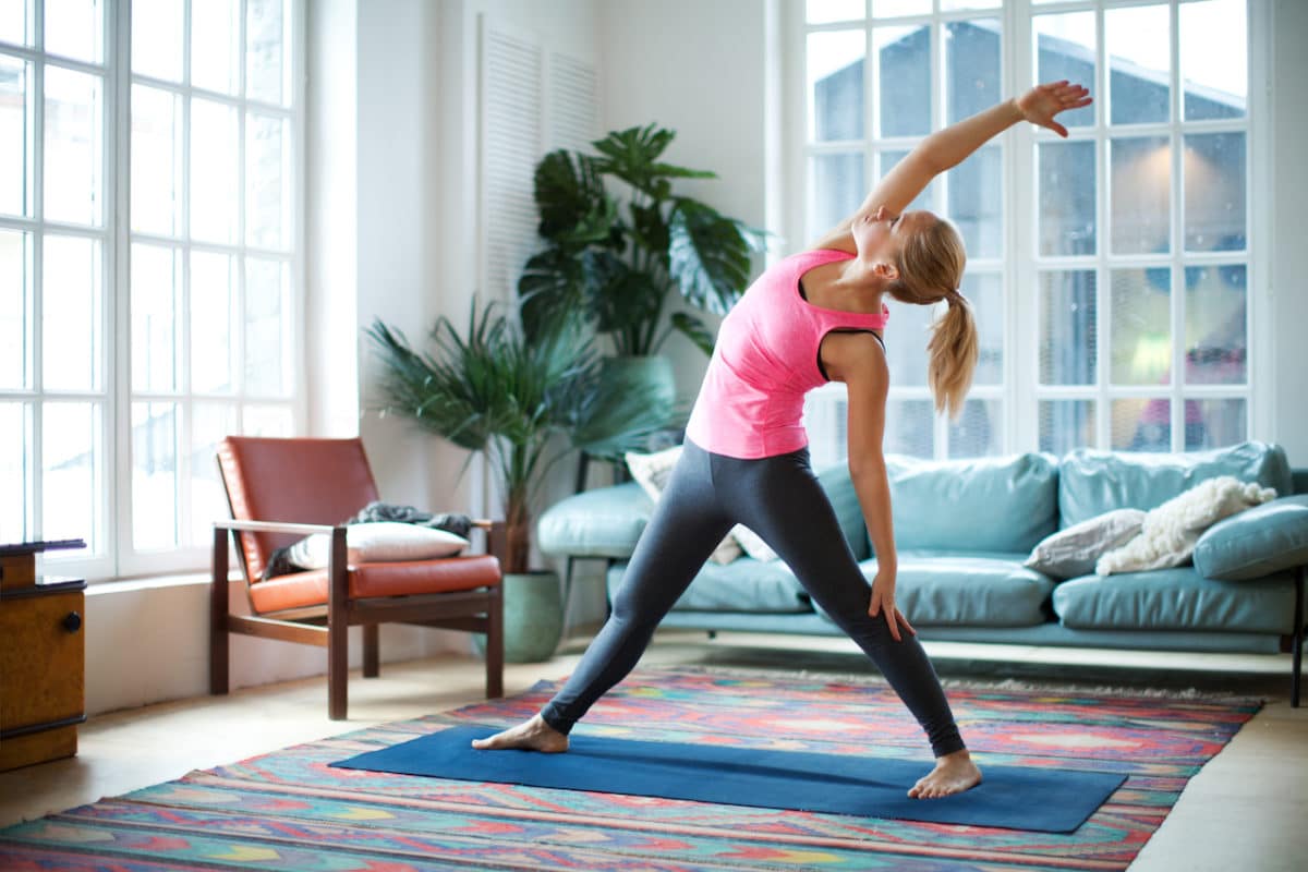 woman doing a yoga pose in her living room