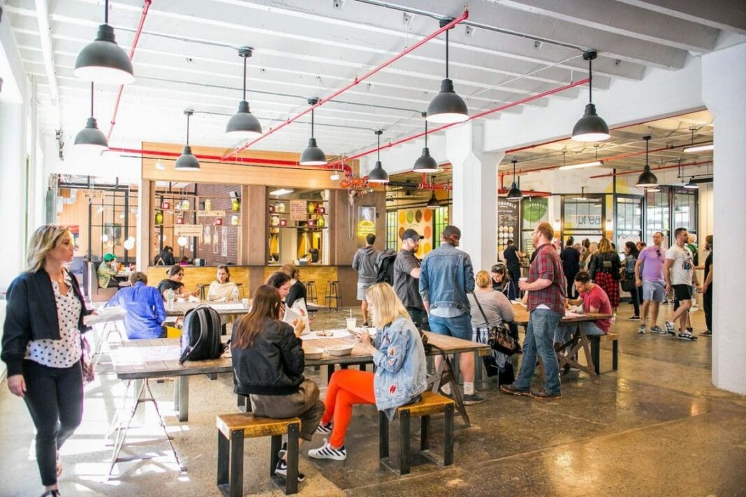 people sitting, waling, and standing in industry city food hall