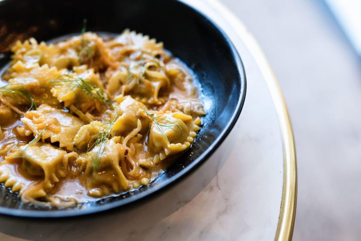 table with black bowl filled wtih raviolis