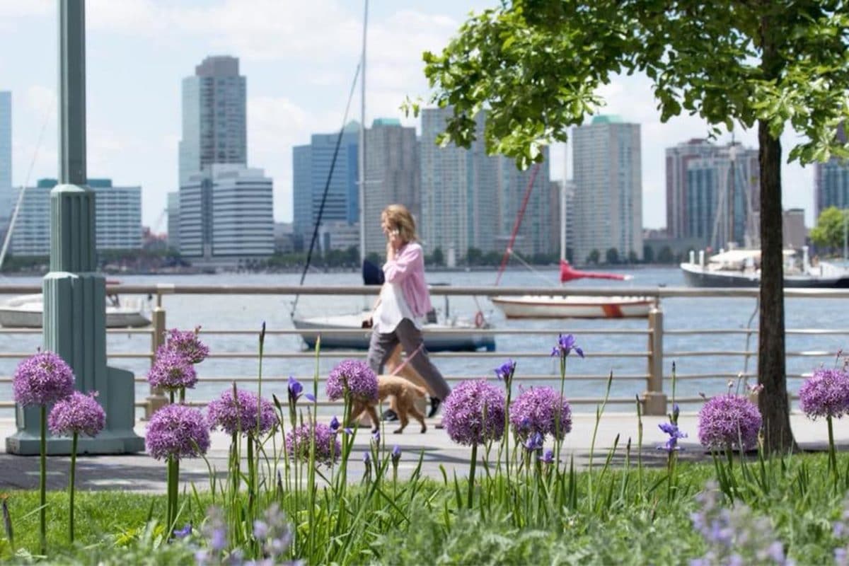 woman strolling along paved path along waterfront 