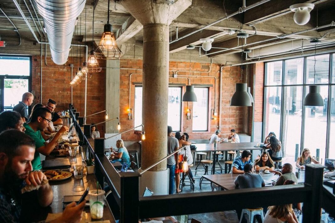 interior of large coffee shop with two levels and people sitting and working 