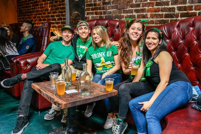 people sitting on leather couch drinking beers