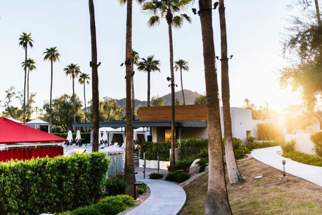 hotel resort with palm trees and sun shining