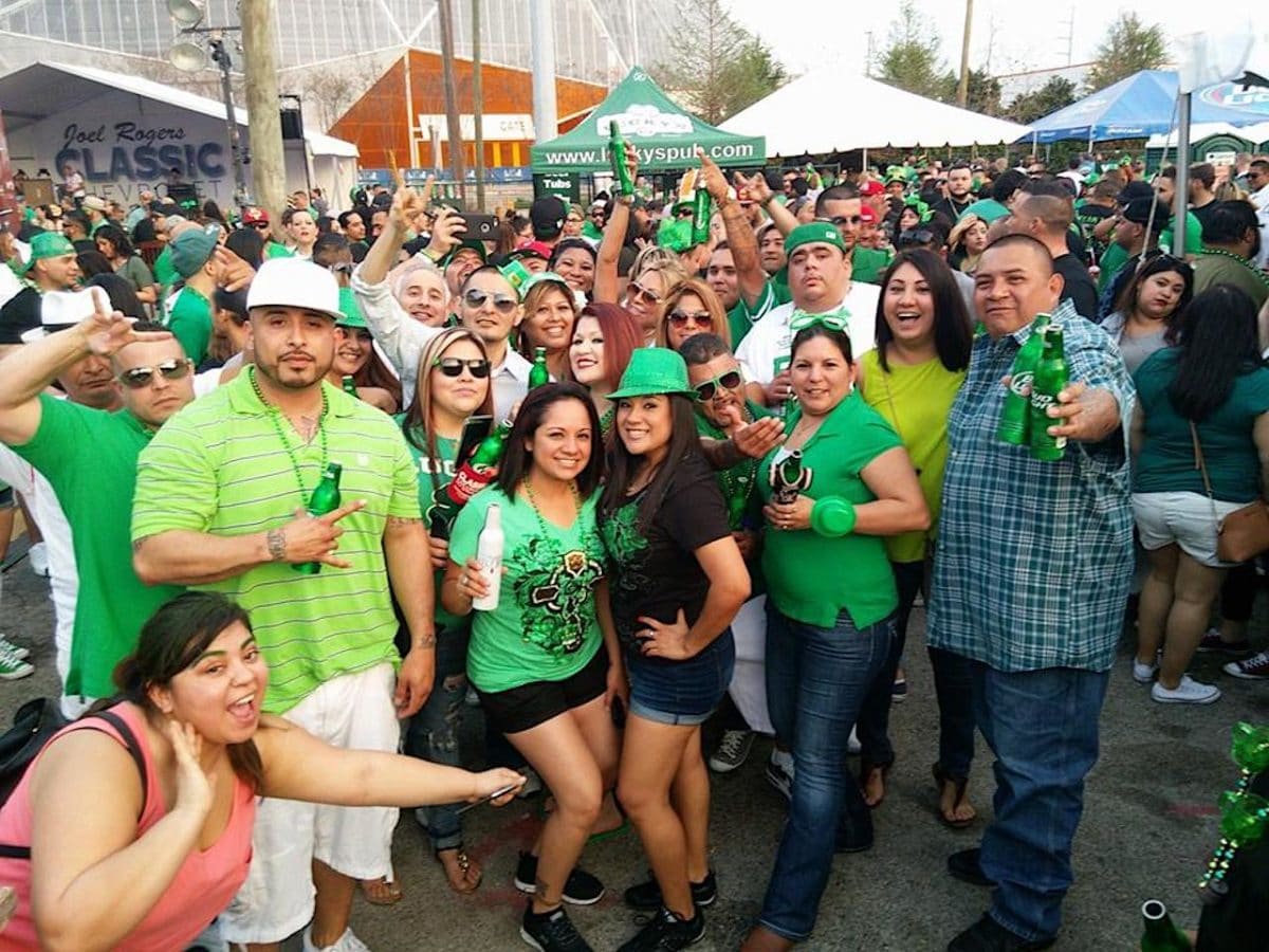 large group of people posing for the camera and wearing shamrocks and green