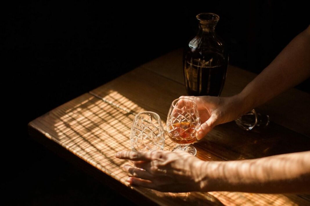 cocktails being places on a table in a dark lounge