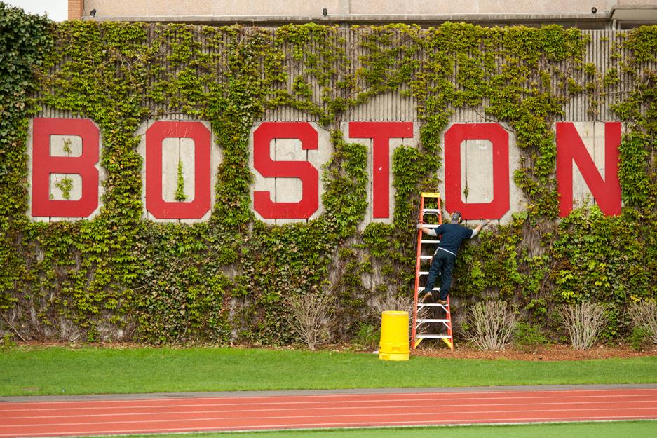 man painting the letters of the word boston on wall