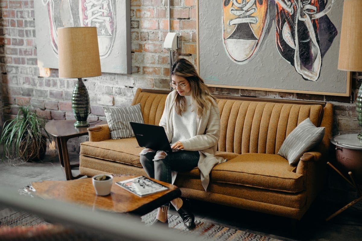 Woman typing on laptop on couch