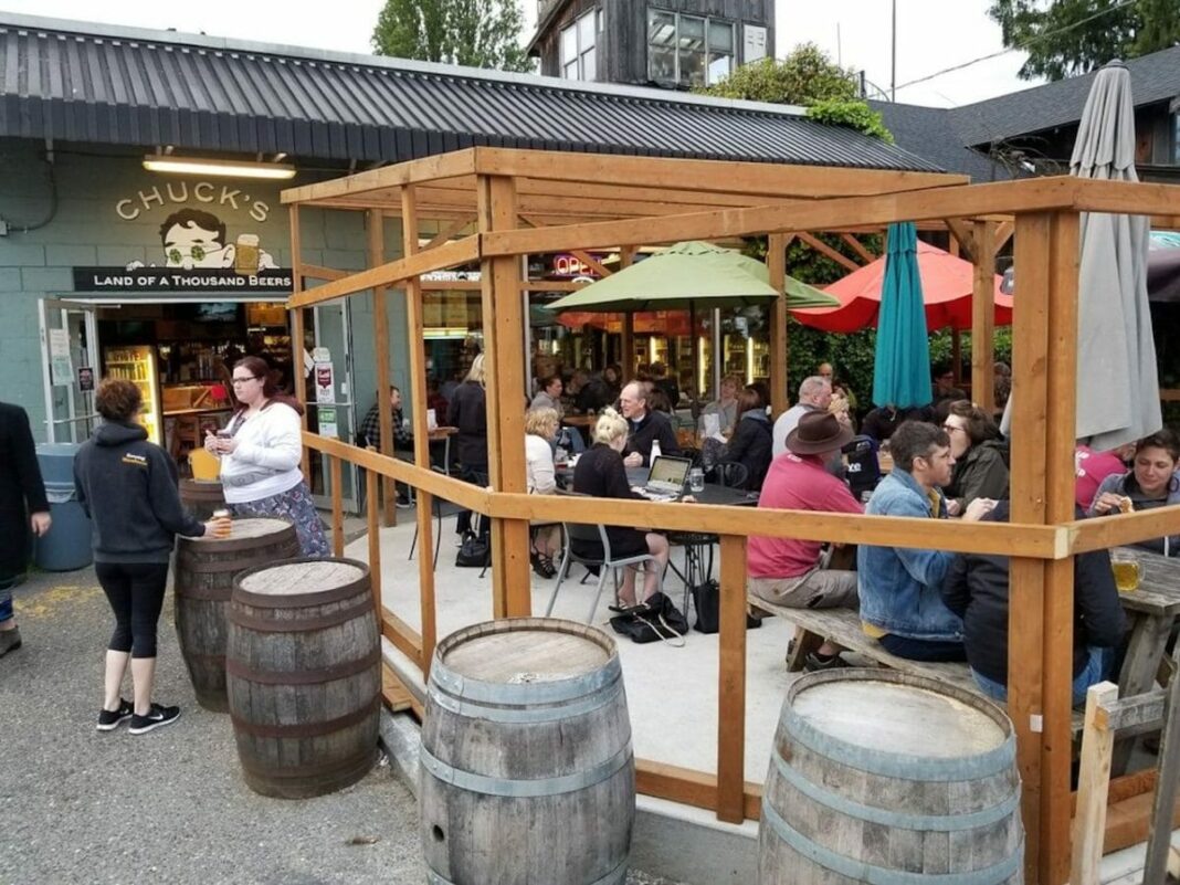 people sitting outside on patio and drinking beers