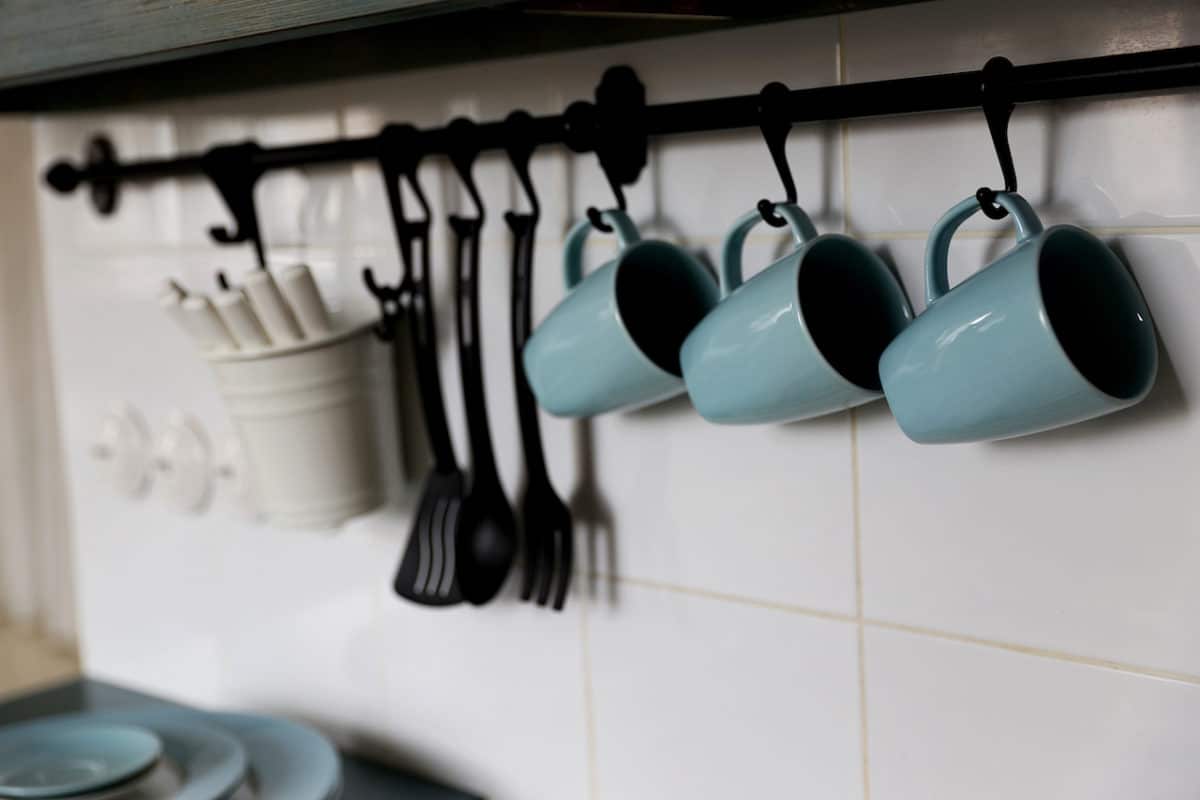 cups hanging on hooks on kitchen wall