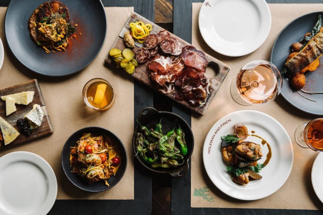 aerial view of table with food plates, cutting board, and cocktails on it
