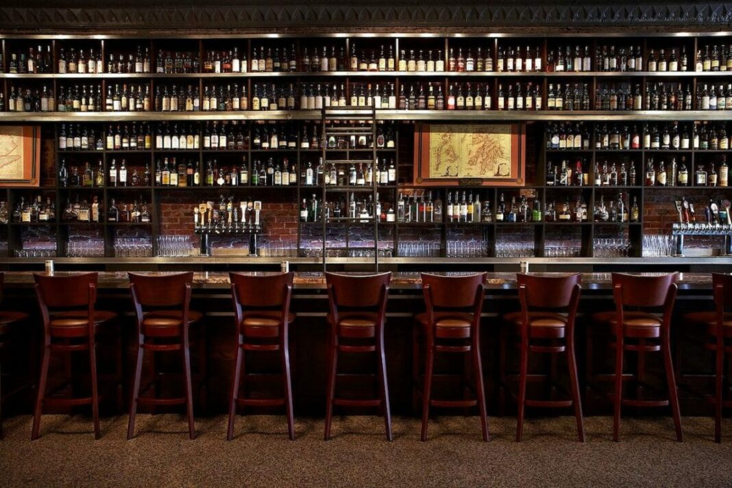 interior of empty bar and bar stools up against bar top