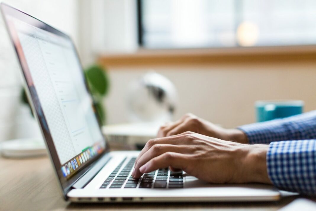 person's hands typing on macbook laptop
