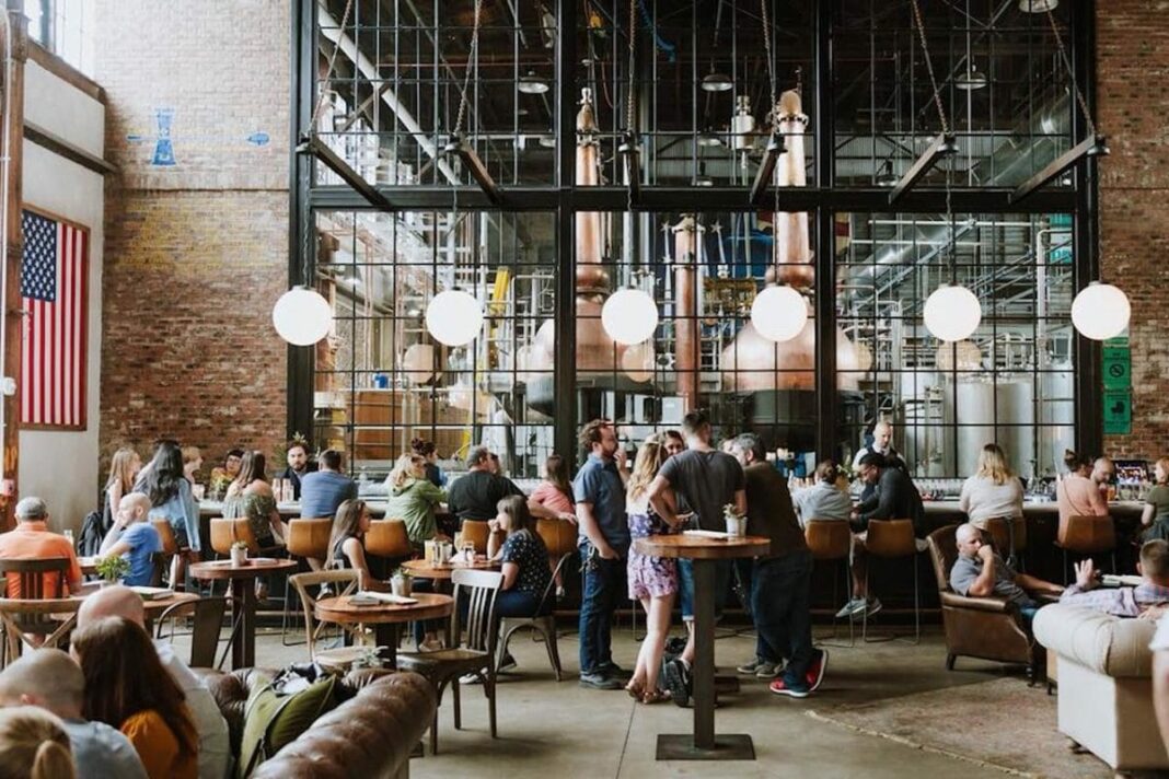 large indoor warehouse space with huge bar and spirit distilling in the background