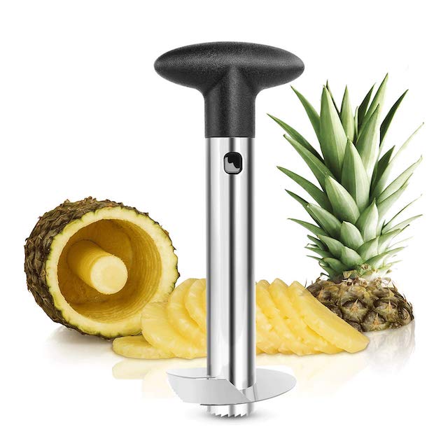 cored out pineapple with slices of pineapple and the top of the pineapple next to it