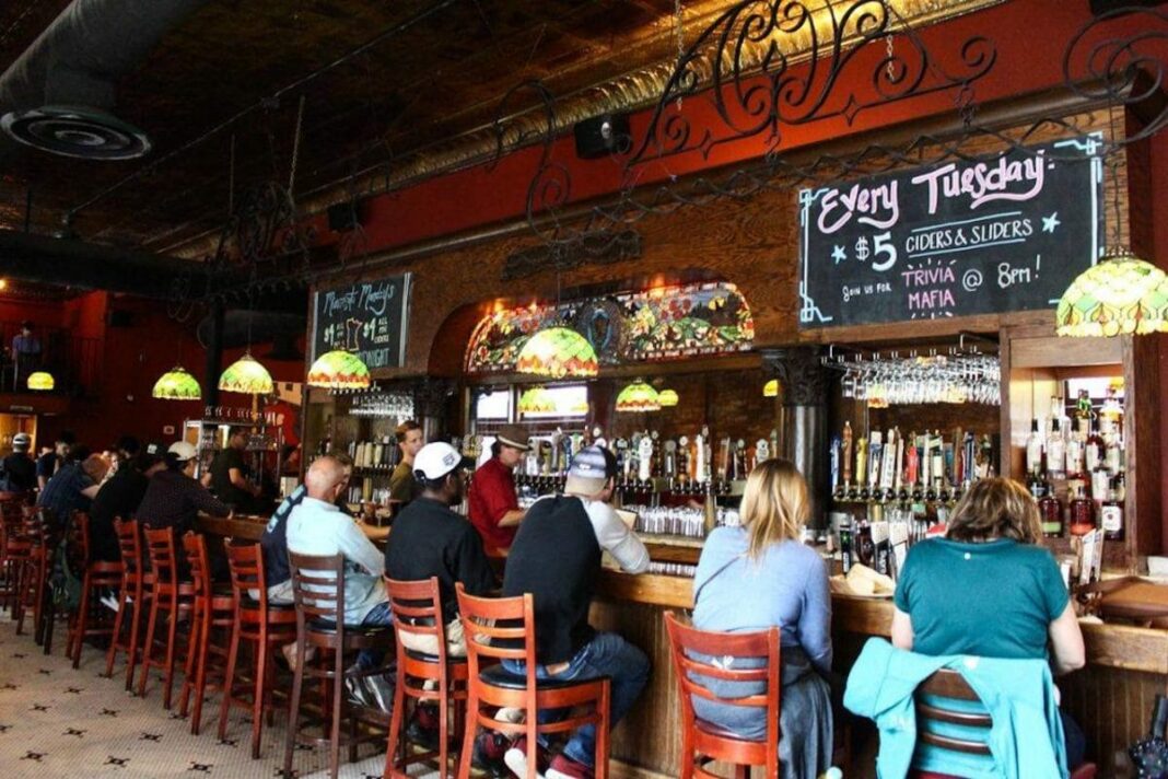people sitting in high chairs at bar 