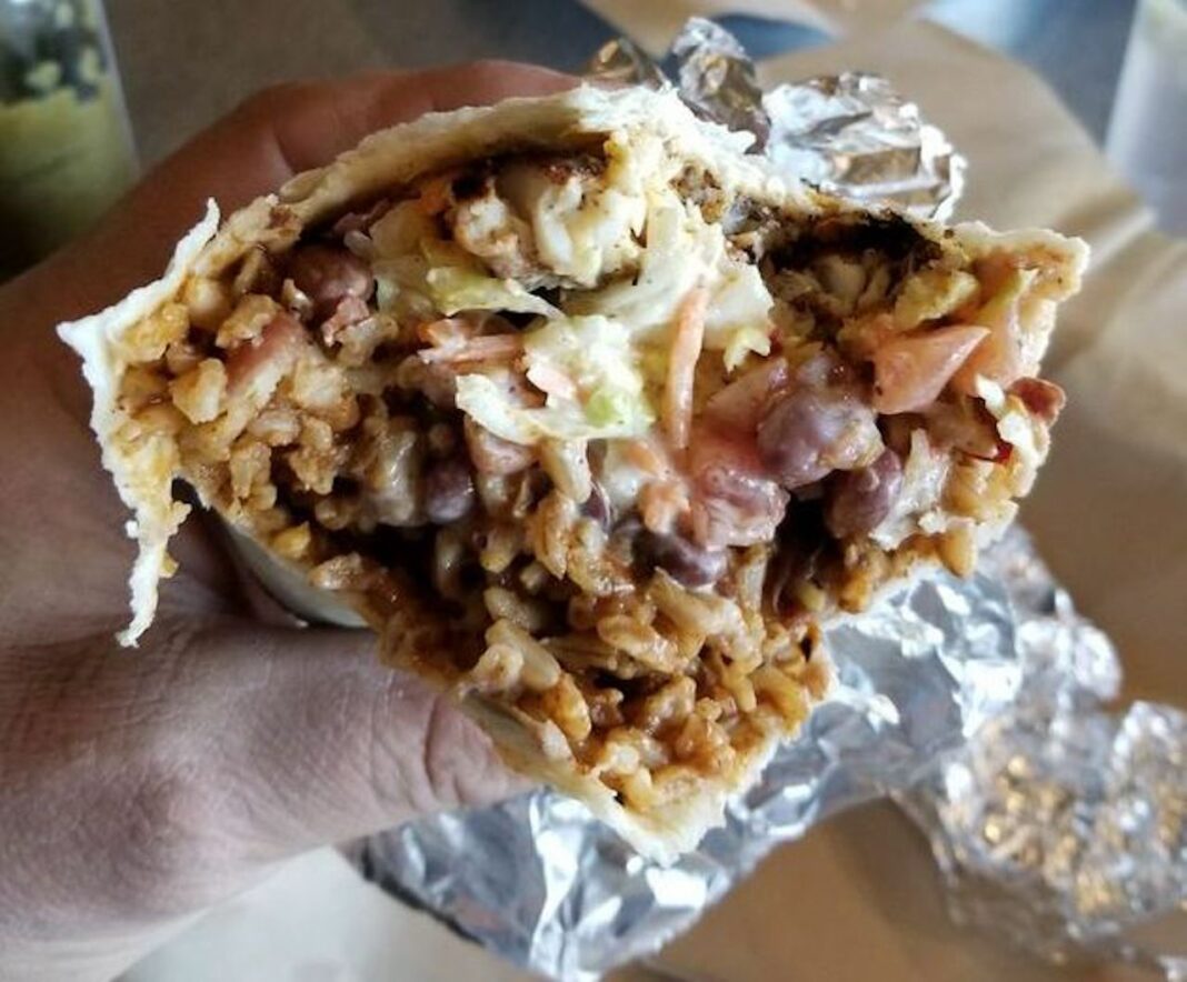 close up of burrito with rice, beans, and gooey center